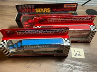 Three boxed Matchbox transporters on table