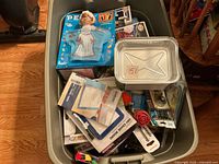 Top view showing PEZ bride set, Funko POP boxes, aluminum pan and mixed items in Rubbermaid tote