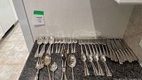 Entire Birks silver-plated flatware set laid out on countertop