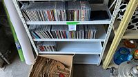 Shelf with rows of compact discs and box of records below
