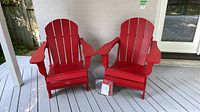 Pair of red folding Adirondack chairs on deck, foreground shows chair included in lot