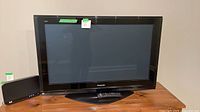 Front view of Panasonic Viera 42-inch television on stand with remote placed on base