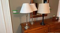 All three table lamps on dresser showing finishes and shades