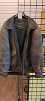 Front view of brown Danier leather jacket on hanger