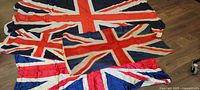 Four Union Jack flags stacked, showing varying sizes and fabrics