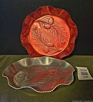 Both embossed aluminum trays front view showing design and edge detail