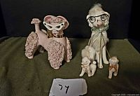 Group view of pink poodle figurine and white poodle family