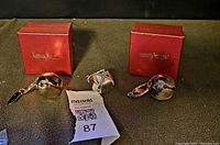 Three bell keychains (gold, two silver) with two Neiman Marcus boxes