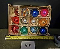 Box containing 12 glass Christmas ball ornaments in divider tray