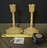 Pair of frosted yellow glass tulip candlesticks with tape measure showing height