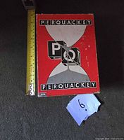 Top view of Perquackey game box with measuring tape for scale