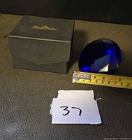 Paperweight beside measuring tape and presentation box