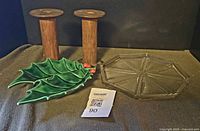 Lot overview showing two wooden spools, ceramic holly dish, pressed glass plate