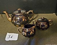 Teapot, sugar bowl with lid, and creamer showing overall design
