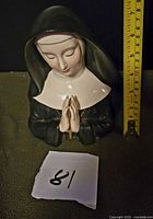Full view of nun head vase with tape measure showing height