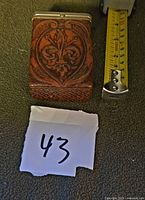 Front view showing fleur-de-lis design and tape measure for scale