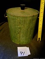 Full view of green wood veneer ice bucket with measuring tape for scale