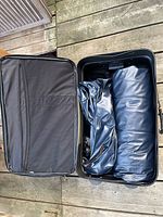 Air mattress folded inside black rolling suitcase