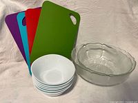 All items grouped: four cutting boards, six white bowls, large glass flower bowl