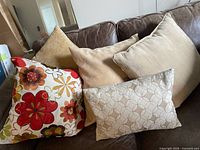 Four pillows on brown leather couch