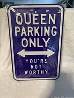 Front view of purple Queen Parking Only stamped steel sign in plastic sleeve