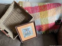 Throw, basket and framed print grouped on couch