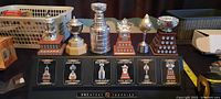 Front view of six miniature NHL trophies on branded stand
