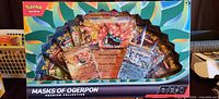 Front of sealed Pokémon TCG Masks of Ogerpon Premium Collection showing promos and booster packs