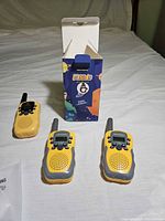 Three yellow/grey walkie talkies, two beside an open FAYOGOO box
