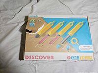 Front of Makedo Discover box showing product name, age range 5+, 126 pieces, damaged tear on lid