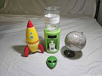 Group shot of rocket bank, water dispenser, alien tin, globe
