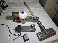 Full view of Dyson handheld vacuum with wand, floor head, wall mount and charger