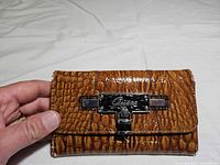 Front view of Guess wallet closed, showing croc texture and metal clasp