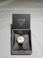 Watch in open Guess box on pillow