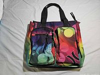 Front view showing multicolor bokeh print, dual handles, two front zip pockets, Hurley logo