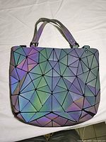Front view of Luminesk geometric reflective tote handbag showing full exterior pattern and handles