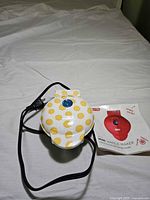 Closed waffle maker with cord and manual visible