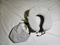 Neck pillow and pouch on white surface