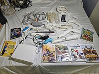 All items laid out: console, cables, controllers, attachments, seven game cases