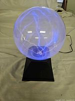 Plasma globe lamp illuminated on black base