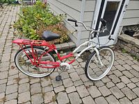 Full side view of red and white Schwinn beach cruiser with rear rack and step-through frame