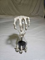 Hourglass front view showing skeletal hand grip top and base