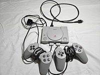 Console, two controllers, HDMI and power cables displayed