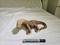Full view of wood lizard next to dry-erase marker for scale
