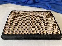 Stack of eight rectangular woven bamboo placemats