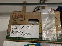 Box containing stacks of clear polyethylene bags with handwritten note "9 1/2" x 12" over 2000"