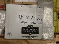 Box labeled 20"x21" 4 mil approx. 1900 pcs with visible stack of clear bags