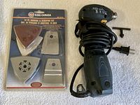 Mastercraft multi-tool with power cord next to sealed King Canada 19-piece sanding & scraping kit and T-handle wrench