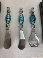 Three utensils front view showing Murano glass handles and stainless steel ends