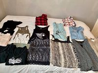 All 17 tops and sweaters laid out on bed